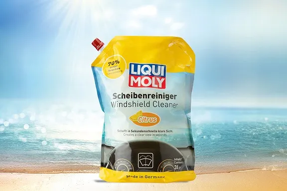 Gelber Liqui Moly Standbeutel für Scheibenreiniger mit Zitrus-Duft vor einer Meereskulisse.